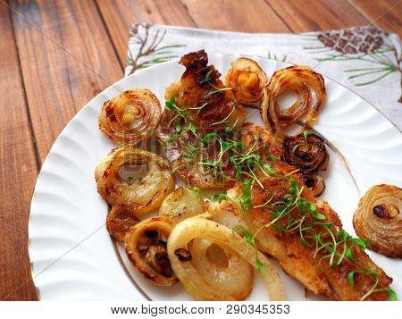 Grilled Fish On White Plate With Onions And Micro Greens