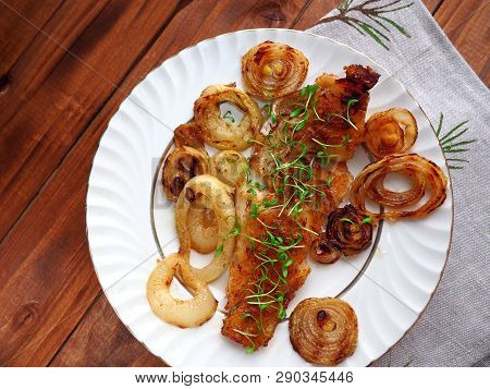 Grilled Fish On White Plate With Onions And Micro Greens