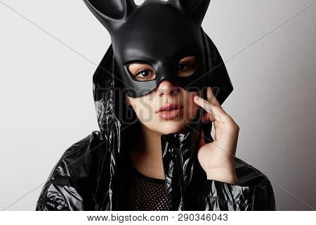 Portrait Of Sexy Young Woman With Red Lipstick And Large Breasts Wearing A Black Mask And Leather Ja