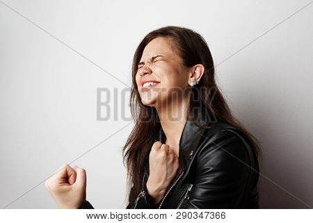 Fashion Photo Of A Beautiful Brunette Woman Wearing Leather Jacket With Dark Long Hair Posing Over W