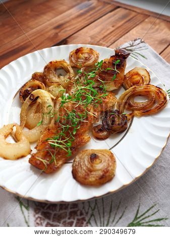 Grilled Fish On White Plate With Onions And Micro Greens
