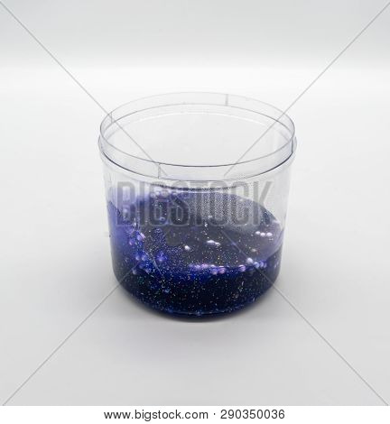 Dark Transparent Blue Glitter Slime In Clear Plastic Container Isolated On White