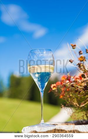 Glass Of Chilled White Wine On A Rocky Mountain Background. Hiking In Dolomites, Italy