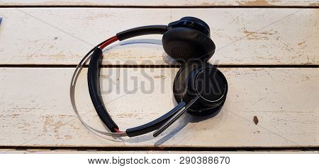Black Wireless Head Phones On Wooden Desk