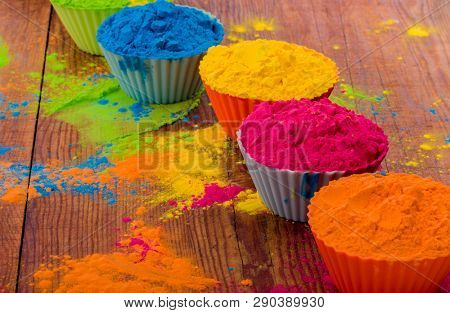 Colorful Holi powder in cups closeup. Bright colours for Indian holi festival in circle of clay pots. Selective focus