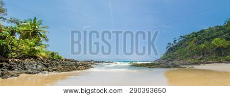 Panoramic Photo Of Itacarezinho Beach, Coconut Trees, Intense Vegetation And Large Stones In Encount