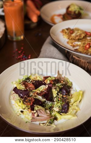 Healthy vegeterian food on brown wood board. Spring vitamin dieting food. Salad from beet with dried tomatoes and cabbage