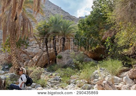 Muscat, Oman - December 16, 2018: Female Tourist Is Walking Along The Wadi - A Dried Up Riverbed - I