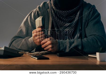 Partial View Of Terrorist In Keffiyeh Scarf Holding Telephone Handset