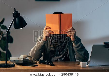 Terrorist In Keffiyeh Scarf With Gun Reading Book In Room