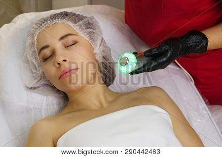Hardware Cosmetology. Ultrasound Chromotherapy. Beautician Carries Out Procedure For Tightening Skin