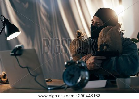 Happy Terrorist Holding Gun And Bags With Money In Room