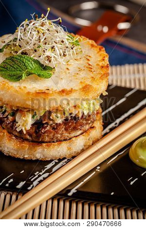 Pan-asian Cuisine Concept. Japanese Sushi Burger Made From Rice Bread, Chicken And Pork Meat Patties