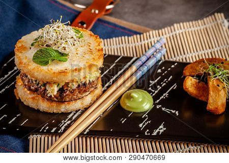 Pan-asian Cuisine Concept. Japanese Sushi Burger Made From Rice Bread, Chicken And Pork Meat Patties