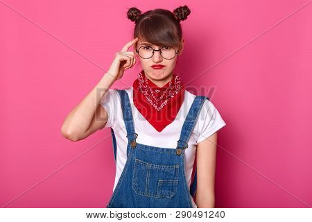 Close Up Portrait Of Brunette Student, Wears Round Eyewear And Red Bandana On Neck, Curves Lips, Kee