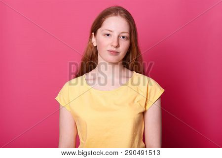 Calm Schoolgirl Of Gentle Appearance, Naturally Posing In Studio Alone, Looks Into Camera Isolated O