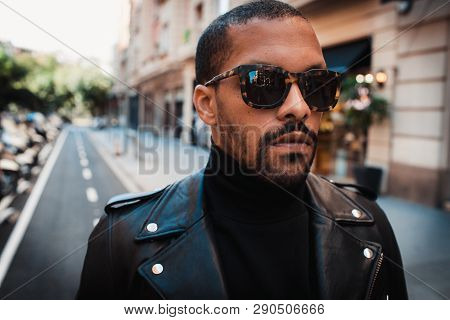 Confident African American Man Wearing On Sunglasses And Black Leather Jacket Outdoor. Street Wear F