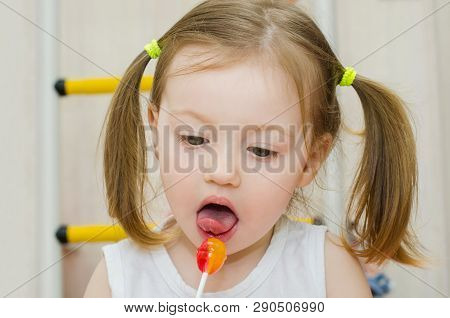 Little Girl Licks Sweet Round Jrange Lollipop