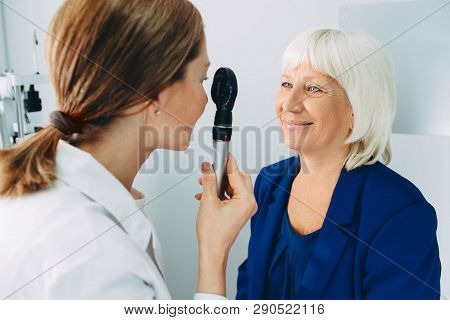 Doctor Examining Old Womans Eye With Ophthalmoscope At Clinic