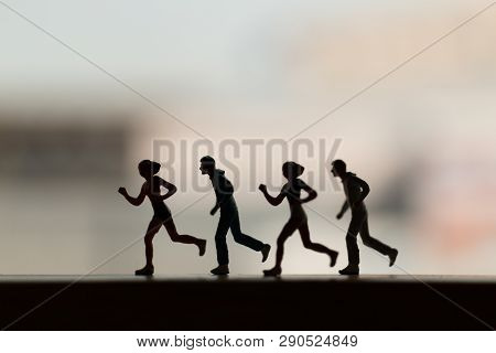 Miniature People Is Running , Silhouette Of A Runner , Health And Lifestyle Concepts.