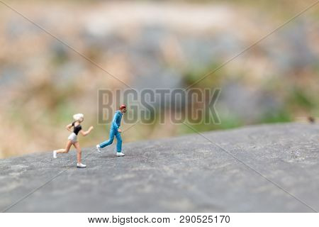 Miniature People Running On The Rock , Health And Lifestyle Concepts.