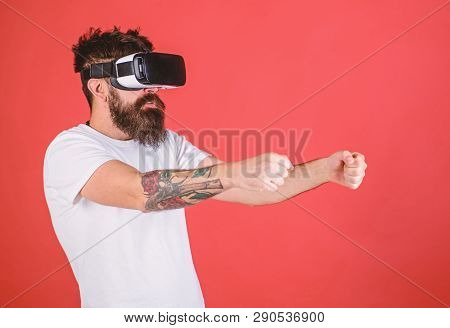 Virtual Racing Concept. Man With Beard In Vr Glasses Driving Car, Red Background. Hipster On Concent