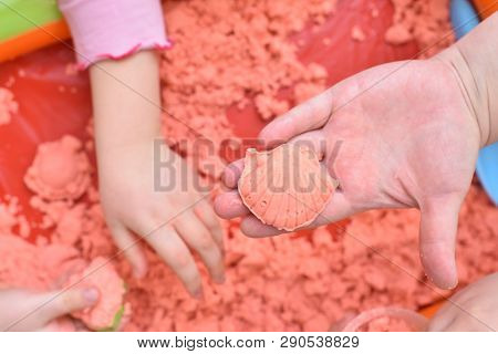 Children Play With Pink Kinetic Sand For Sculpting Figures And Show Their Hands. Top View, Hands Clo