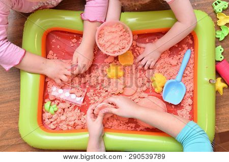 Children Play With Pink Kinetic Sand For Sculpting Figures. Top View, Hands Close Up