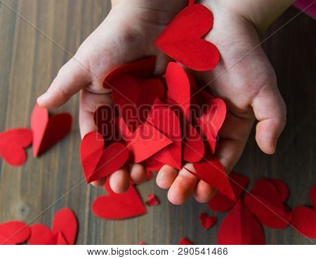 Red Hearts From Paper In Childs Hands On The Wood Background. A Gift For Valentines Day And Mothers 
