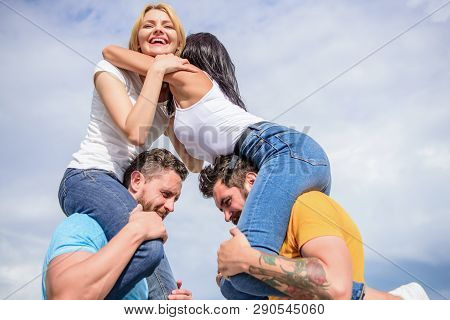 Couples In Love Having Fun. Men Carry Girlfriends On Shoulders. Summer Vacation And Fun. Couples On 