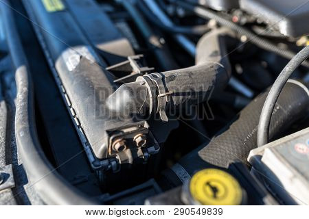Hose Connecting The Car Radiator With The Engine, In The Background The Engine Compartment.