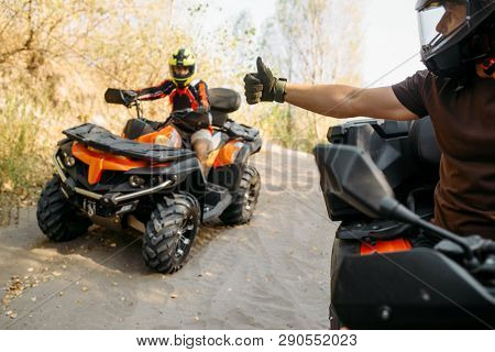 ATV rider showing thumbs up to his partner 