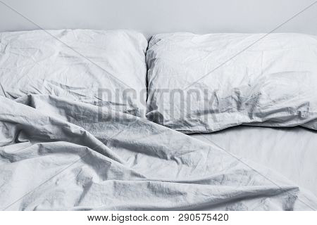 Messy Gray Bed Linen. Bed With Two Pillows In Daylight.