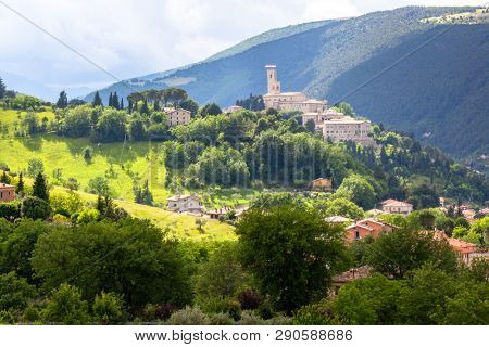 An image of Camerino in Italy Marche over colourful fields