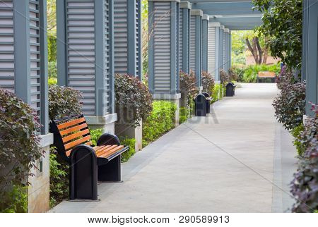 Empty outdoors promenade with resting chairs and bush in a new park,China