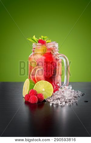 Homemade Raspberry Mint Lemonade With Berries And Lime On A Green Background