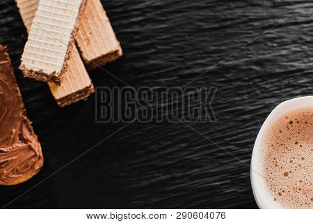 Close-up Of Coffee Cup With Roasted Coffee Beans On Wooden Background. View From Top