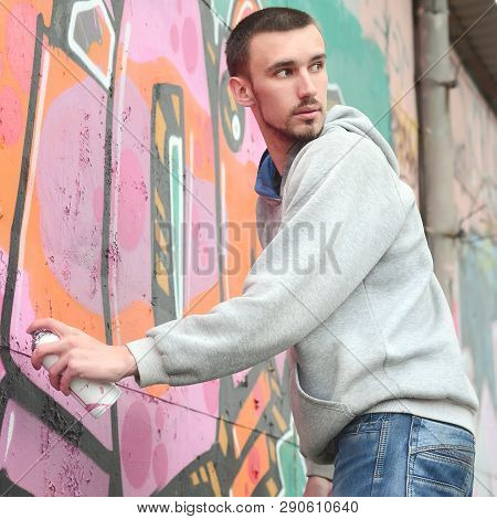 A Young Graffiti Artist Looks Around While Drawing. Vandal Tries