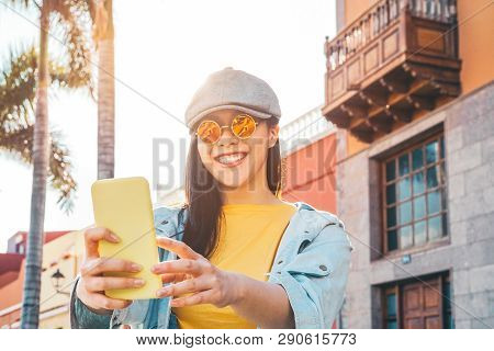Happy Asian Girl Using Mobile Smartphone Outdoor - Chinese Social Influencer Having Fun Making Video
