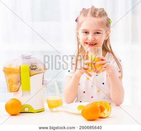 Braided girl enojoying morning glass of orange juice