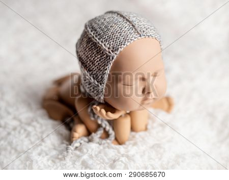 Plastic mannequin of baby, made for posing, in frog stand, isolated
