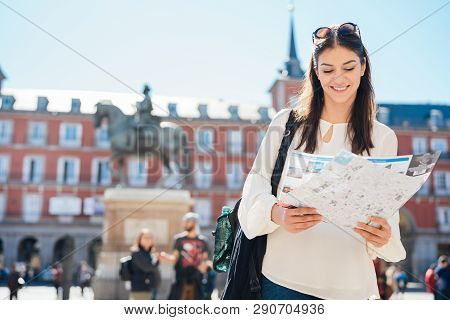 Visiting Famous Landmarks And Places.cheerful Female Traveler At Famous Plaza Mayor Square Admiring