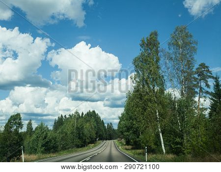 Fields, Trees And Road With Blue Sky And Clouds