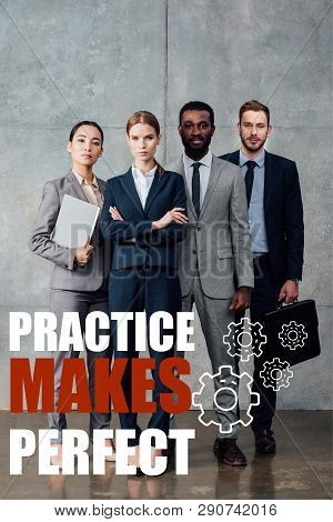 Focused Multiethnic Group Of Businesspeople In Formal Wear Posing And Looking At Camera With Practic
