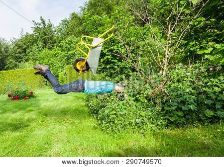 Man Flies With Wheelbarrow In A Bush.