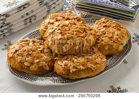 Dish with traditional Moroccan small bastella with roasted almond topping on a nice set table