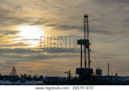 Oil And Gas Drilling Rig Onshore Dessert With Dramatic Cloudscape. Oil Drilling Rig Operation On The