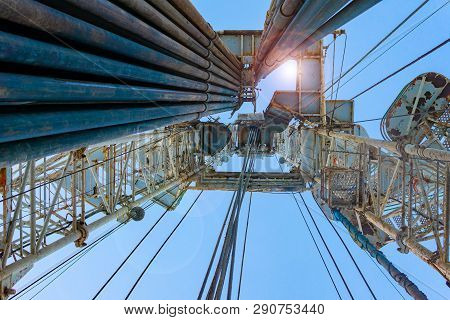 Oil And Gas Drilling Rig Onshore Dessert With Dramatic Cloudscape. Oil Drilling Rig Operation On The