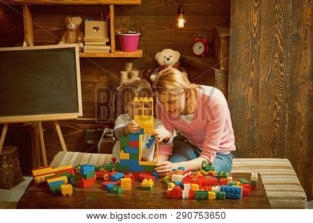 Building Concept. Mother And Son Play With Building Blocks. Mother And Child Build Structure With To
