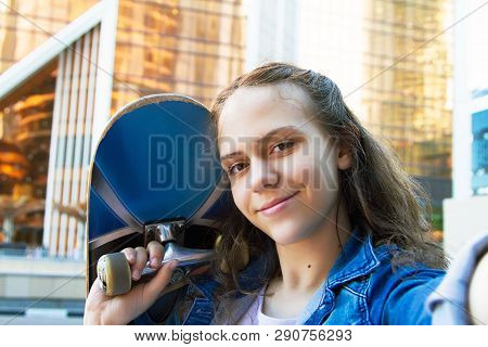 Selfie Photo Of Happy Teen Girl Holding A Skateboard On Her Shoulder